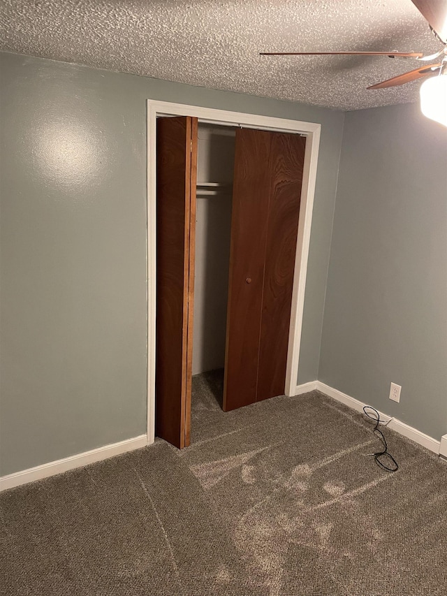 unfurnished bedroom with ceiling fan, carpet floors, a textured ceiling, and a closet