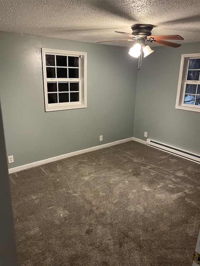 unfurnished room with ceiling fan, dark carpet, and a textured ceiling