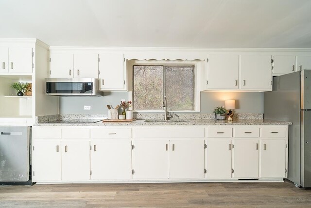 kitchen featuring white cabinetry, appliances with stainless steel finishes, sink, and light hardwood / wood-style floors