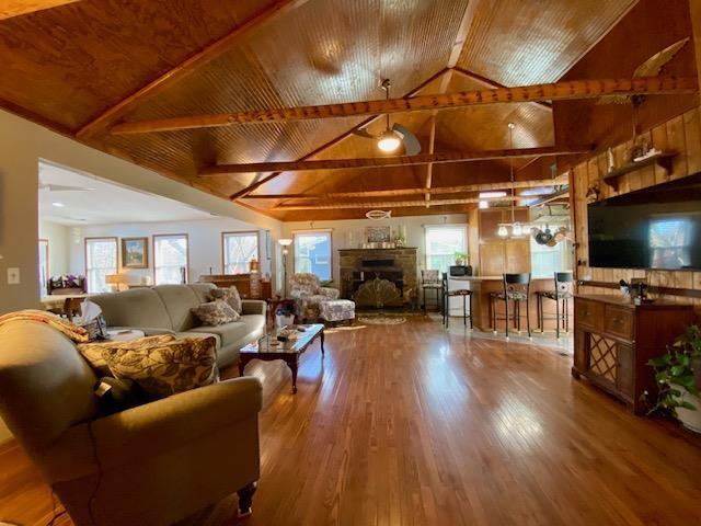 living room featuring hardwood / wood-style floors, wood ceiling, and lofted ceiling with beams