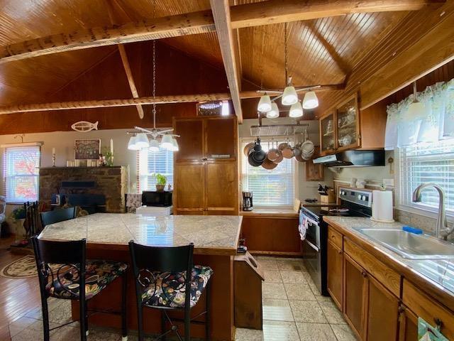 kitchen featuring decorative light fixtures, a breakfast bar, sink, and range with two ovens