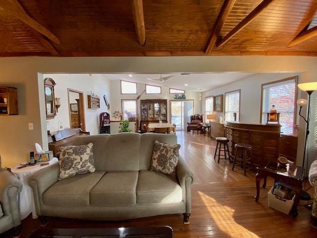 living room with wood ceiling, lofted ceiling with beams, and hardwood / wood-style floors