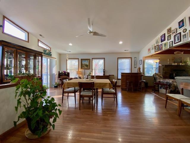 dining space with lofted ceiling, wood-type flooring, and ceiling fan