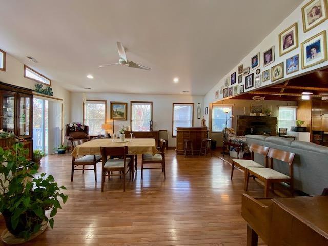 dining area featuring hardwood / wood-style flooring, vaulted ceiling, and ceiling fan