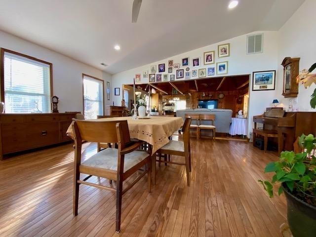 dining area featuring vaulted ceiling, wood-type flooring, and ceiling fan