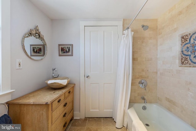 bathroom with shower / bath combo with shower curtain and a sink