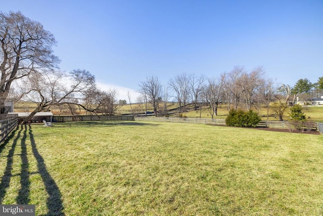 view of yard featuring a rural view and fence