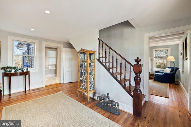 stairway featuring visible vents, recessed lighting, baseboards, and wood finished floors