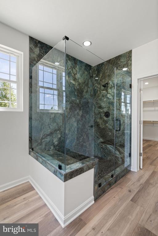 bathroom with an enclosed shower and hardwood / wood-style flooring