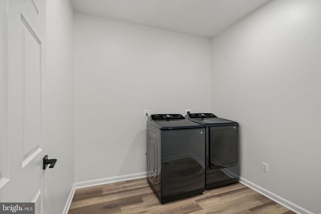 clothes washing area featuring washer and dryer and light hardwood / wood-style flooring