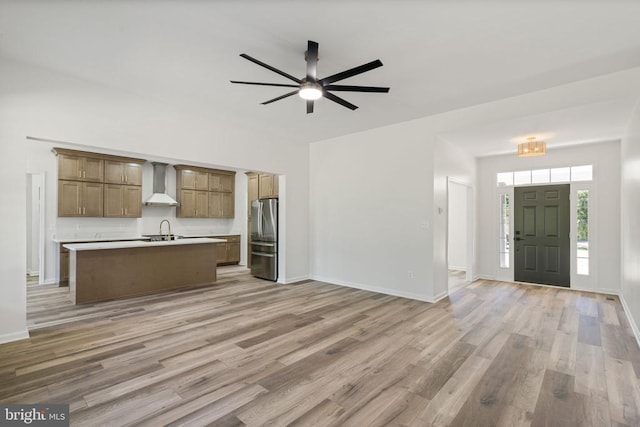 interior space with light wood-type flooring, baseboards, a sink, and ceiling fan