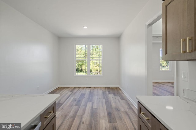 unfurnished dining area with baseboards, light wood-style floors, and recessed lighting