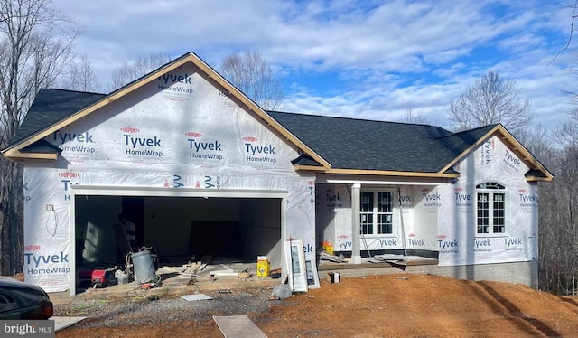 property in mid-construction featuring a shingled roof and a garage