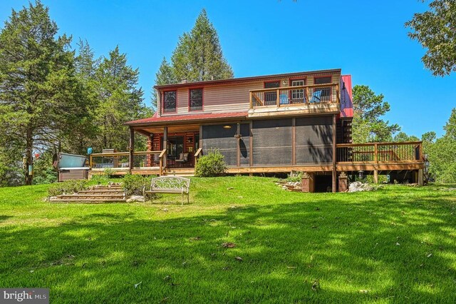 back of house featuring a yard and a sunroom