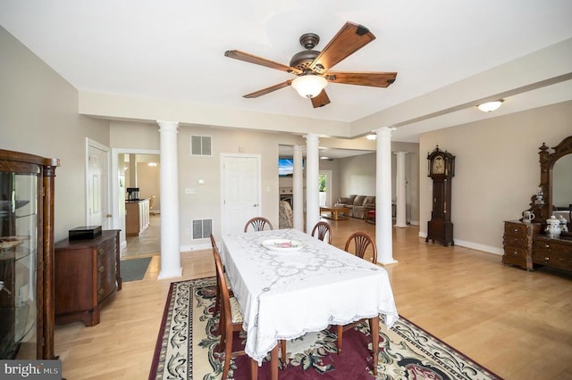 dining space with light wood-type flooring, decorative columns, and visible vents