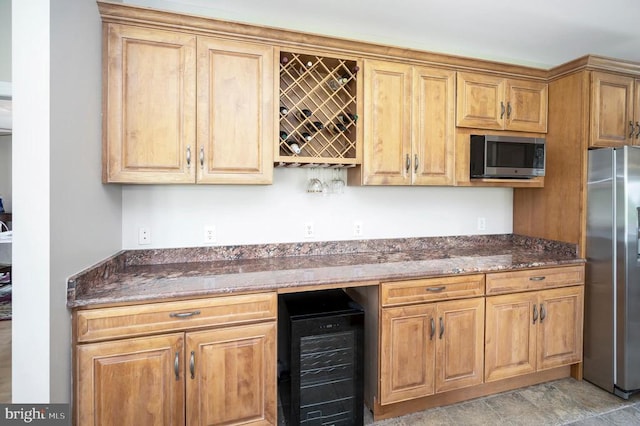 kitchen featuring appliances with stainless steel finishes, wine cooler, and dark stone countertops