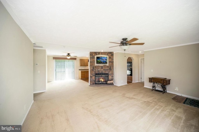 unfurnished living room with ceiling fan, light carpet, a large fireplace, baseboards, and crown molding