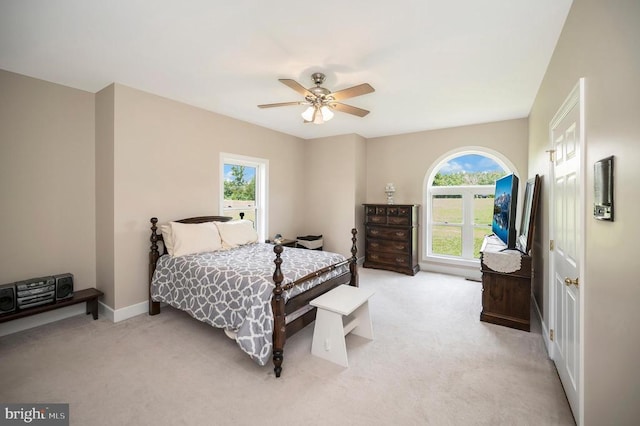 bedroom featuring light carpet, ceiling fan, and baseboards