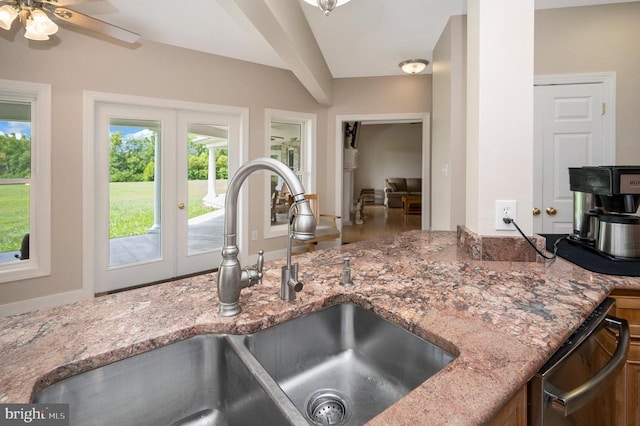 kitchen featuring dishwashing machine, light stone counters, a sink, and french doors