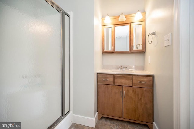 bathroom featuring a stall shower, vanity, and baseboards