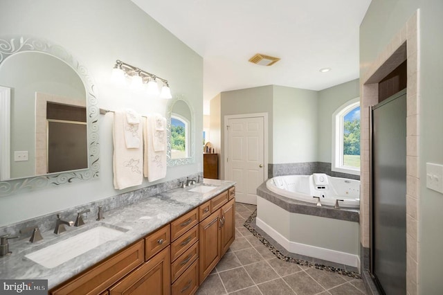 bathroom with visible vents, a sink, a tub with jets, and tile patterned floors