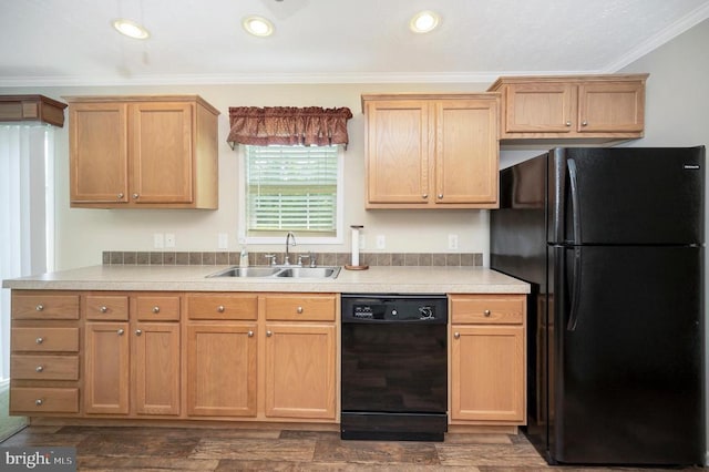 kitchen featuring dark wood-type flooring, light countertops, crown molding, black appliances, and a sink