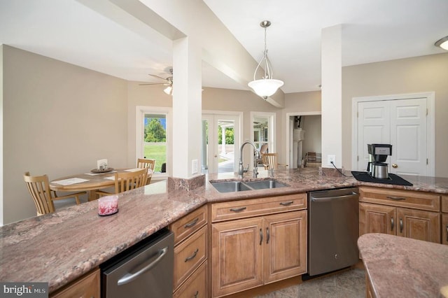 kitchen with light stone counters, dishwasher, and a sink