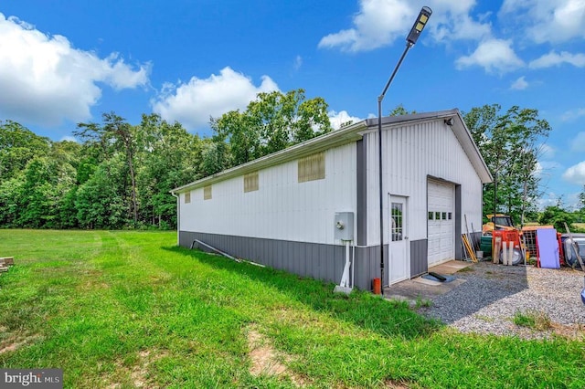 view of side of home featuring an outbuilding, a yard, and a detached garage