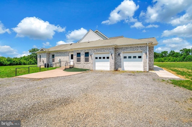 view of front facade featuring gravel driveway, brick siding, fence, and an attached garage