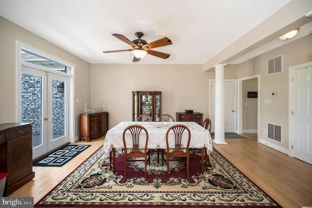 dining area featuring decorative columns, visible vents, and french doors