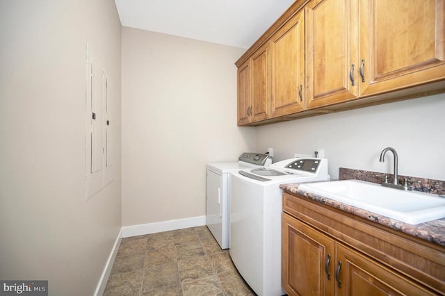 laundry room featuring cabinet space, stone finish flooring, a sink, separate washer and dryer, and baseboards