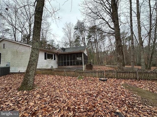 back of property with a sunroom and central AC