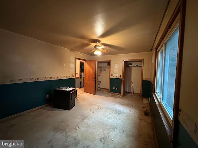 unfurnished bedroom featuring multiple closets and ceiling fan