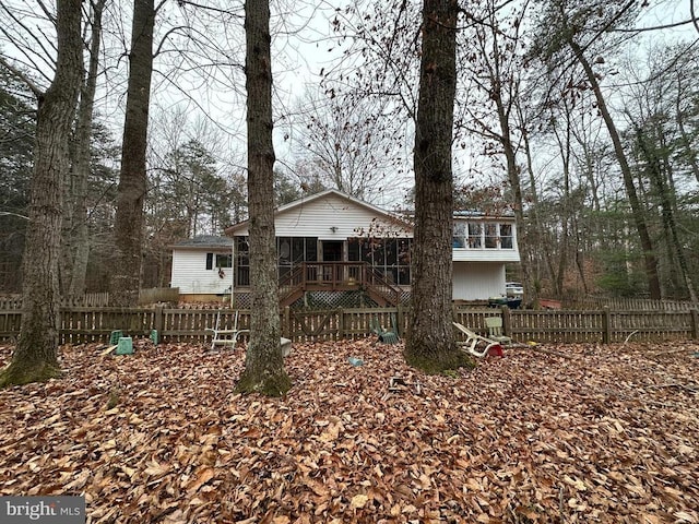 rear view of property featuring a sunroom