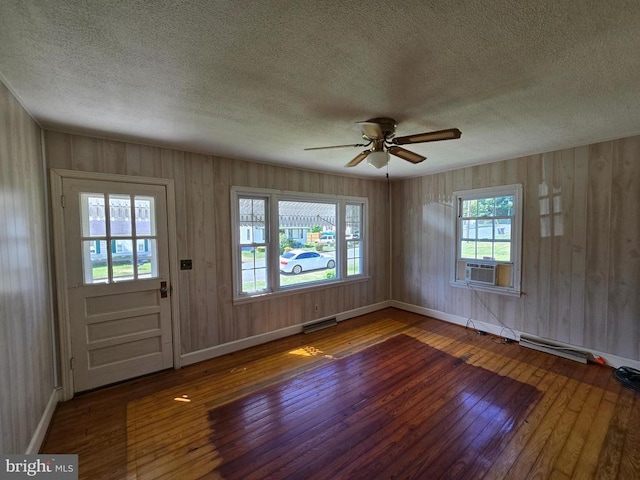 entrance foyer featuring ceiling fan, a textured ceiling, baseboards, wood-type flooring, and cooling unit