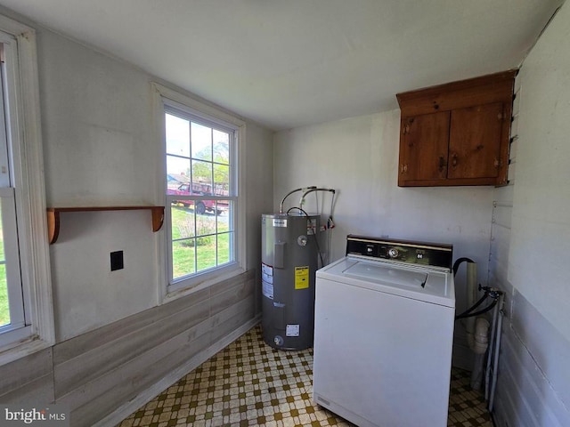 clothes washing area with water heater, light floors, cabinet space, and washer / clothes dryer