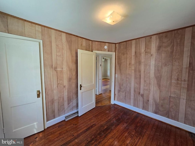 unfurnished bedroom featuring wooden walls and wood finished floors