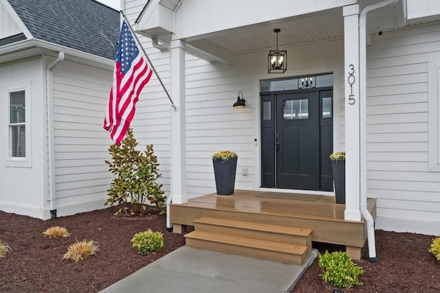 entrance to property featuring roof with shingles