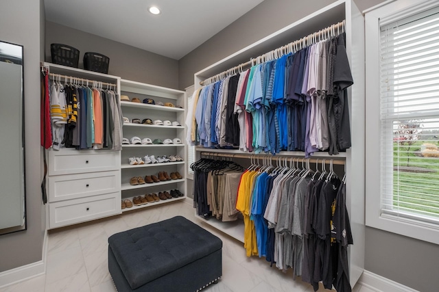 walk in closet featuring marble finish floor
