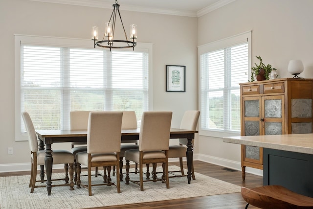 dining area featuring an inviting chandelier, wood finished floors, ornamental molding, and baseboards