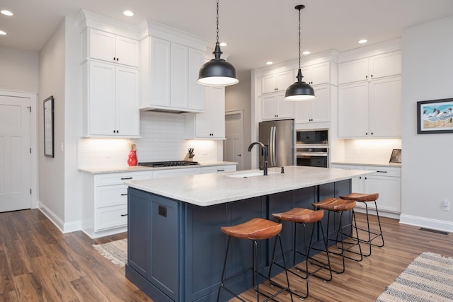 kitchen with baseboards, recessed lighting, stainless steel appliances, and a sink