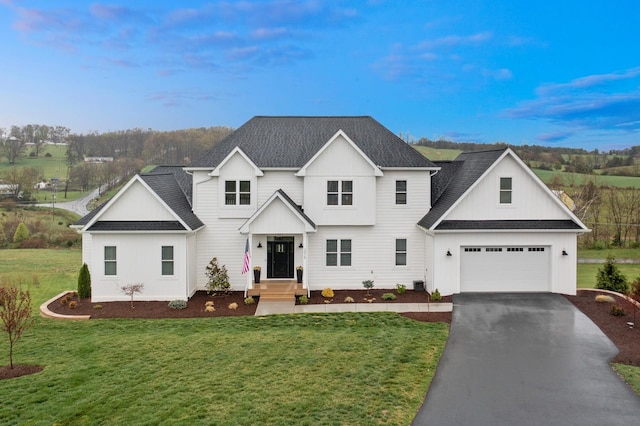 view of front of home with driveway, roof with shingles, and a front yard