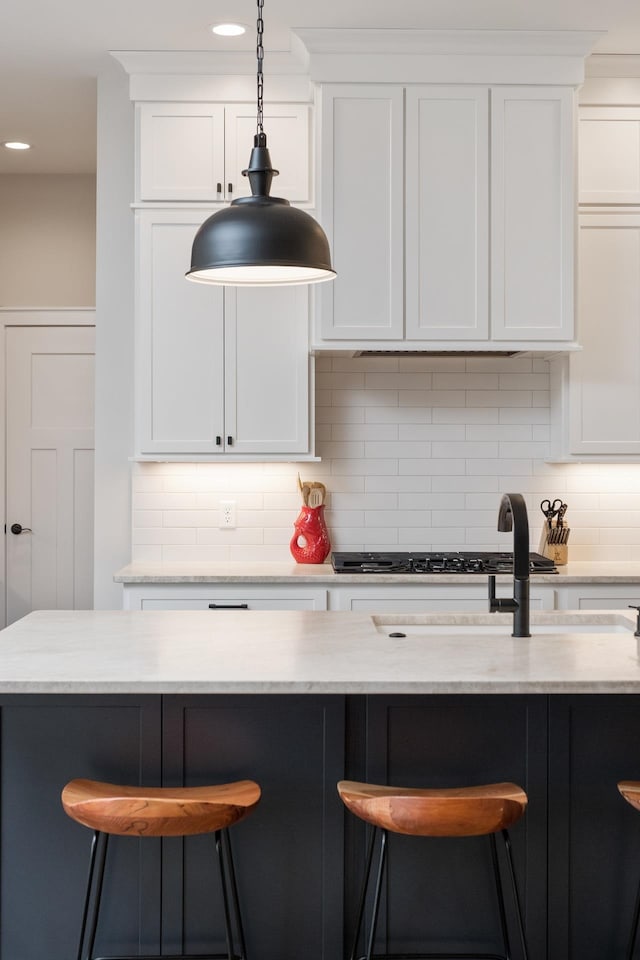 kitchen with a breakfast bar area, backsplash, and hanging light fixtures