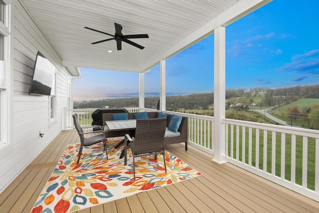 wooden deck with ceiling fan and outdoor dining area