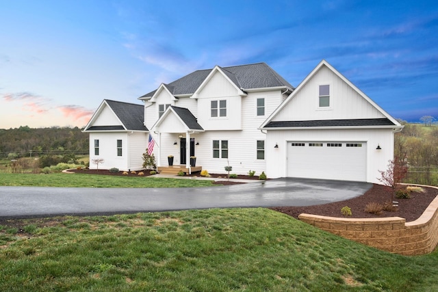 view of front of house with concrete driveway, a front lawn, and a garage