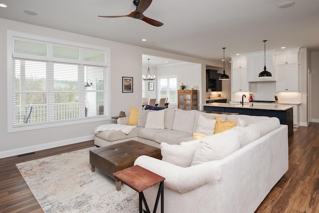 living area with recessed lighting, dark wood finished floors, visible vents, baseboards, and ceiling fan with notable chandelier