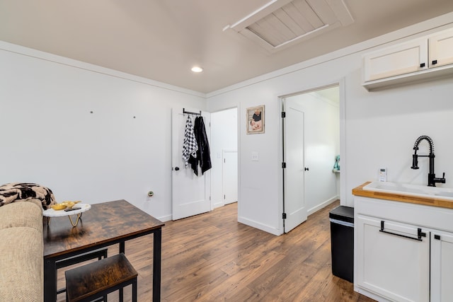 kitchen with dark hardwood / wood-style flooring, sink, and white cabinetry