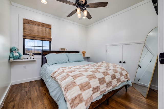 bedroom featuring ceiling fan, ornamental molding, dark hardwood / wood-style floors, and a closet