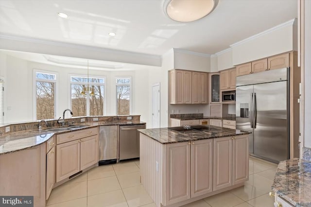 kitchen featuring built in appliances, plenty of natural light, crown molding, a kitchen island, and a sink