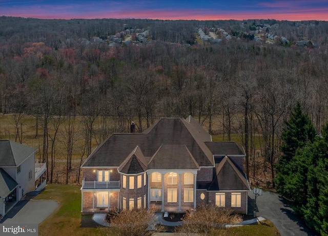 aerial view at dusk with a wooded view